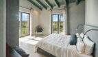 Helles Schlafzimmer der Finca Portocolom mit Doppelbett, Holzbalkendecke und Balkon mit Landschaftsblick