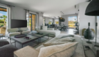Helles Wohnzimmer der Finca bei Portocolom mit modernen Sofas, Esstisch und Panoramablick auf die Landschaft.