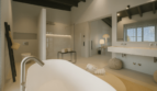Luxuriöses Badezimmer der Finca bei Portocolom mit freistehender Badewanne, Walk-in-Dusche und elegantem Doppelwaschbecken.