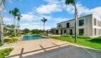 Finca Portocolom: Moderner Pool mit Palmen, weitläufige Terrasse und mediterrane Villa in traumhafter Außenanlage