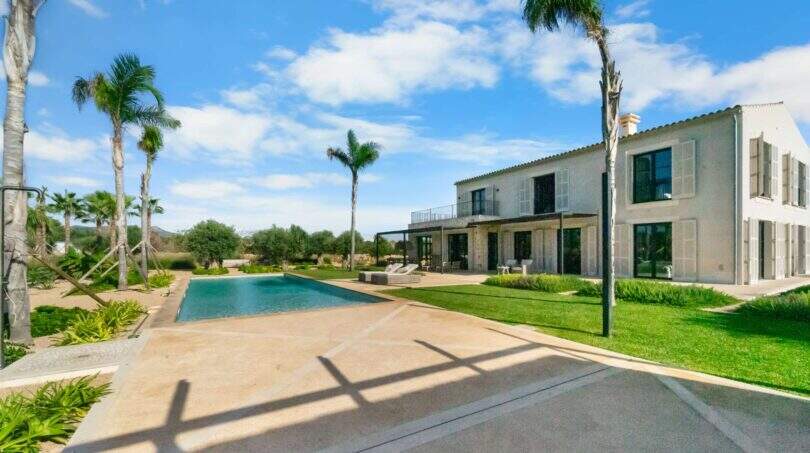 Finca Portocolom: Moderner Pool mit Palmen, weitläufige Terrasse und mediterrane Villa in traumhafter Außenanlage