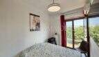 Luminoso dormitorio con cama doble, aire acondicionado y acceso a balcón con vista al verde en Palma