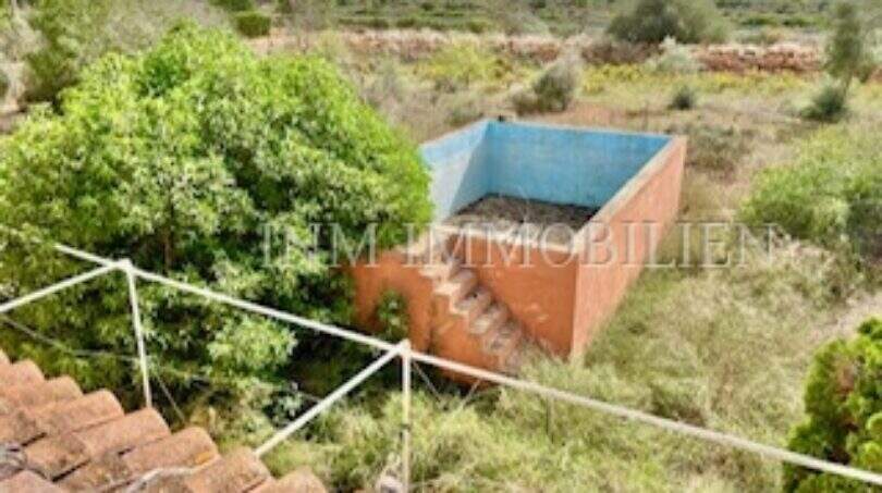 Blick vom Dach auf leeren Pool und Naturlandschaft der Finca in Llucmajor