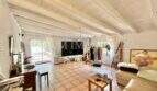 Geräumiges Wohnzimmer mit Holzbalkendecke, Terrakottaboden und Terrassenzugang in Finca Llucmajor