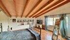 Schlafzimmer mit Holzbalkendecke, Terrakottaboden und Doppelbett in Finca Llucmajor