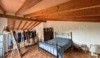 Schlafzimmer mit Doppelbett, Holzbalkendecke und Terrakottaboden in Finca Llucmajor