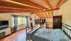 Rustikales Schlafzimmer mit Holzbalkendecke, Terrakottaboden und Eisenbett in Finca Llucmajor