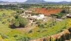 Luftaufnahme einer Finca in Llucmajor mit zwei Wohneinheiten, umgeben von Feldern und Olivenbäumen mit Bergblick.