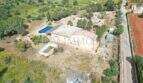 Luftaufnahme einer Finca in Llucmajor mit Pool, zwei Wohneinheiten und großem Grundstück mit Vegetation.