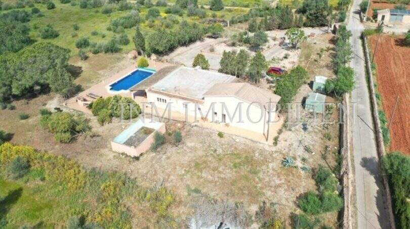 Luftaufnahme einer Finca in Llucmajor mit Pool, zwei Wohneinheiten und großem Grundstück mit Vegetation.