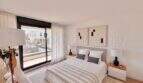 Dormitorio luminoso con cama doble, decoración moderna y acceso al balcón con vistas exteriores en la casa de nueva construcción Puig de Ros