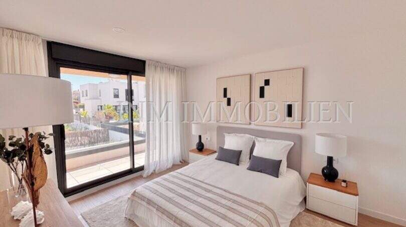 Dormitorio luminoso con cama doble, decoración moderna y acceso al balcón con vistas exteriores en la casa de nueva construcción Puig de Ros