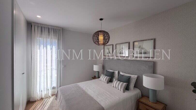 Dormitorio luminoso en la casa de nueva construcción Puig de Ros con cama doble, lámpara colgante y diseño elegante.