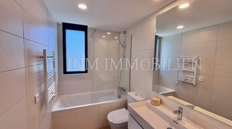 Cuarto de baño moderno con bañera, ducha, inodoro y lavabo doble en la casa de nueva construcción en Puig de Ros