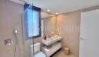 Cuarto de baño moderno con ducha de lluvia, lavabo mural e inodoro en casa de nueva construcción Puig de Ros, Llucmajor