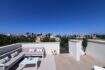Terraza en la azotea soleada con muebles lounge y vista panorámica sobre Puig de Ros en Llucmajor, Mallorca.