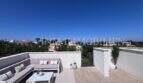 Terraza en la azotea soleada con muebles lounge y vista panorámica sobre Puig de Ros en Llucmajor, Mallorca.