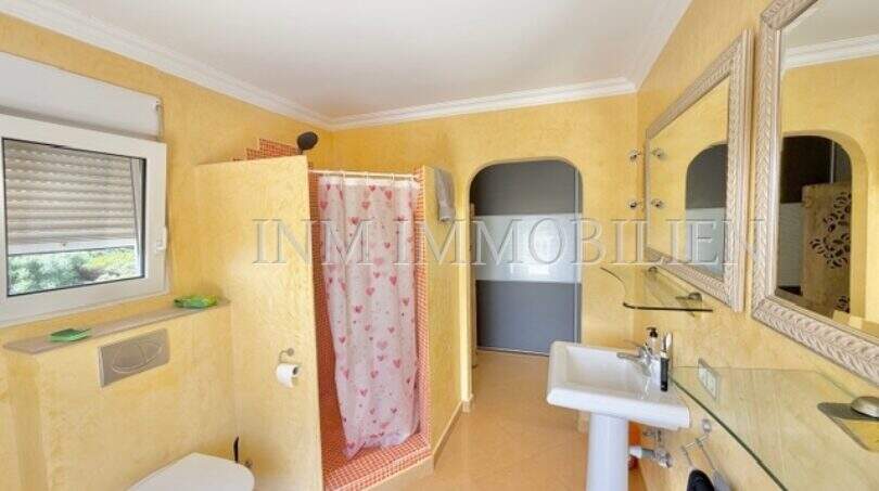 Helles Badezimmer mit gelbem Wandputz, Dusche mit Vorhang, Wandtoilette und Waschtisch im Chalet Vallgornera