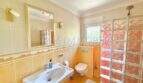 Helles Badezimmer mit Waschbecken, WC, Glasbausteindusche und gelblichen Fliesen im Chalet Vallgornera