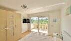 Helles Schlafzimmer mit Einbauschrank, Deckenventilator und Glastür zum Balkon mit Grünblick in Vallgornera