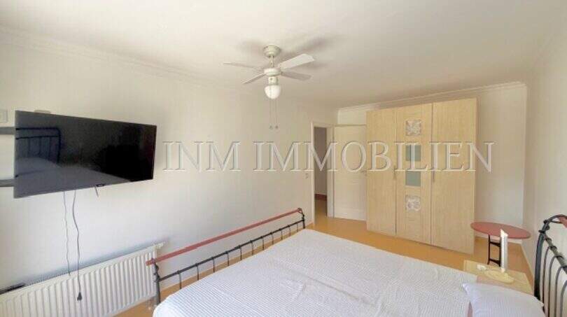 Helles Schlafzimmer im Chalet Vallgornera mit Doppelbett, Deckenventilatoren, TV und Einbauschrank.