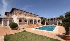 Außenansicht Chalet Vallgornera: mediterrane Villa mit Pool, Terrasse, Balustrade und gepflegtem Garten in Cala Pi.