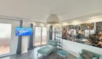 Bright living room with turquoise furniture, wall art, TV and balcony access in sea view apartment Palma
