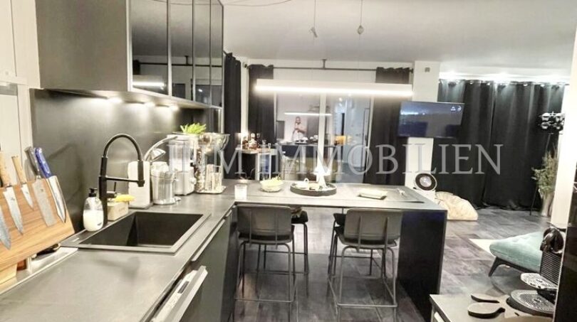 Modern open kitchen with kitchen island, dark fronts and bar stools in sea view apartment Palma de Mallorca
