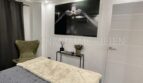 Modern bedroom of the sea view apartment in Las Maravillas with double bed, TV wall art and elegant armchair.