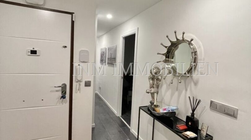Bright entrance area of the sea view apartment in Las Maravillas with modern console table and decorative mirror.