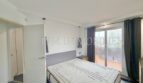 Bright bedroom with double bed, access to balcony and modern pendant lights in sea view apartment Palma