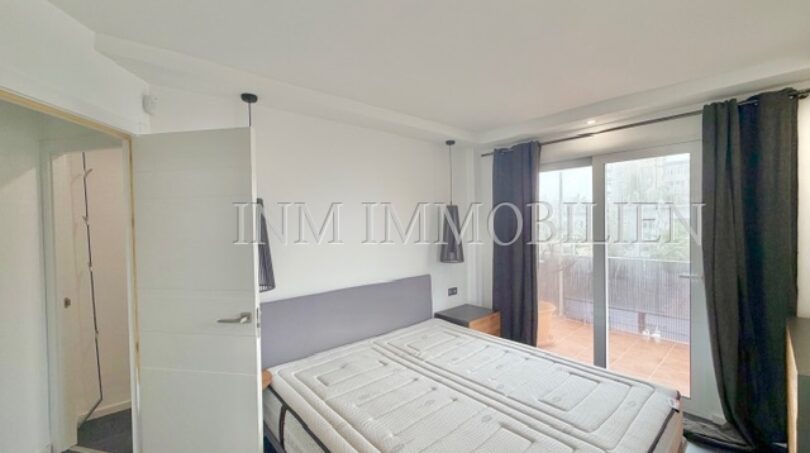 Bright bedroom with double bed, access to balcony and modern pendant lights in sea view apartment Palma