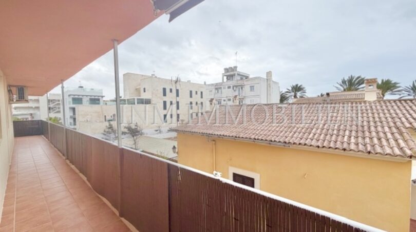 Spacious balcony with bamboo privacy screen and view of neighboring buildings and palm trees in Las Maravillas, Palma