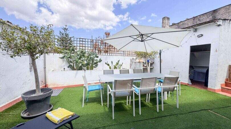 Sonnige Dachterrasse mit Esstisch, Sonnenschirm, Kunstrasenfläche und Kakteen in Felanitx
