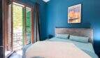 Stilvolles Schlafzimmer mit blauer Wandfarbe, Doppelbett, Balkon und Mallorca-Poster in Felanitx