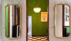 Flur mit zwei goldgerahmten Wandspiegeln, Kristallleuchter und markanter grüner Wand in stilvoller Wohnung Felanitx