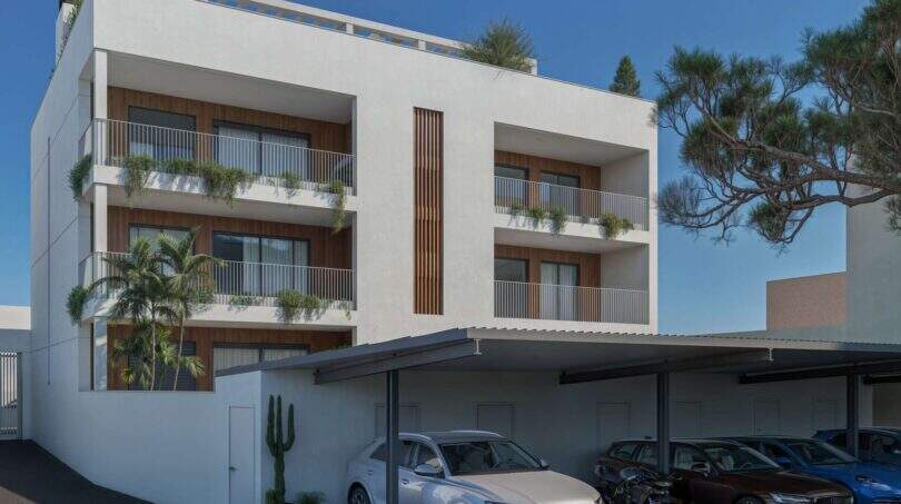 Modernes Mehrfamilienhaus in Porto Cristo mit Balkonen, Holzverkleidung und überdachtem Parkplatz, Außenansicht