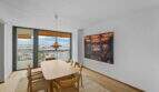 Elegantes Esszimmer der Luxuswohnung am Paseo Marítimo mit Hafenblick, Holztisch und moderner Hängeleuchte.