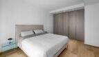 Helles Schlafzimmer der Luxuswohnung am Paseo Marítimo mit Doppelbett, Einbauschrank und Holzboden.