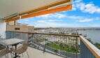 Balkon der Luxuswohnung am Paseo Marítimo mit Meerblick, Hafenpanorama und orangefarbenem Sonnensegel