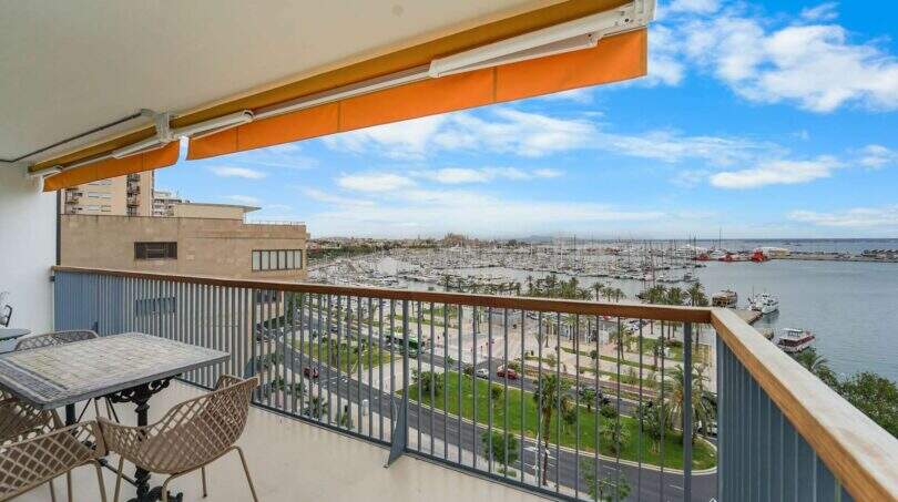 Balkon der Luxuswohnung am Paseo Marítimo mit Meerblick, Hafenpanorama und orangefarbenem Sonnensegel