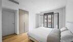 Helles Schlafzimmer der Luxuswohnung am Paseo Marítimo mit Doppelbett, Einbauschrank und Balkonzugang.