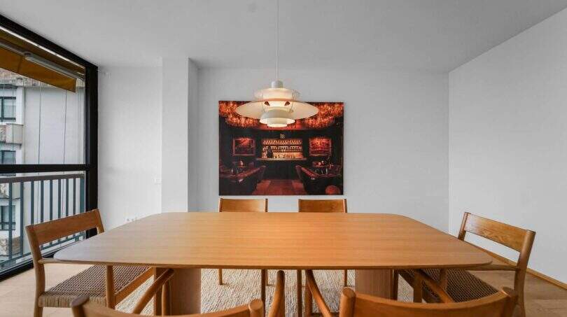 Elegantes Esszimmer der Luxuswohnung in Palma mit Holztisch, Designerstühlen und moderner Pendelleuchte.