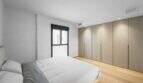 Helles Schlafzimmer der Luxuswohnung am Paseo Marítimo mit Einbauschränken und Holzboden