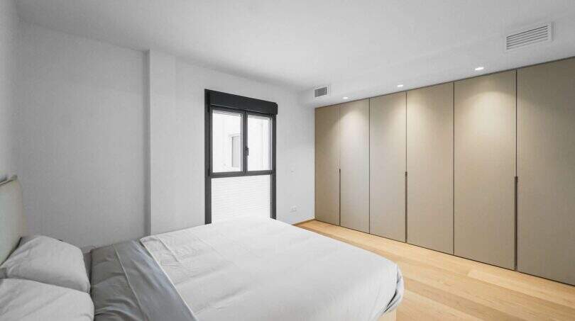 Helles Schlafzimmer der Luxuswohnung am Paseo Marítimo mit Einbauschränken und Holzboden