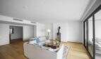 Helles Wohnzimmer der Luxuswohnung am Paseo Marítimo mit Holzboden, Kaminofen und Zugang zur Terrasse.