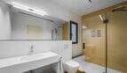 Modernes Badezimmer der Luxuswohnung am Paseo Marítimo mit Dusche, WC und großem Spiegel.