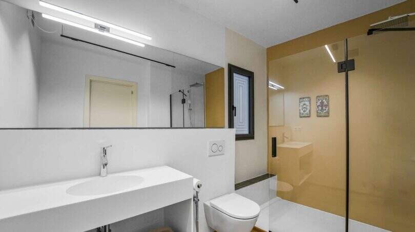 Modernes Badezimmer der Luxuswohnung am Paseo Marítimo mit Dusche, WC und großem Spiegel.