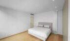 Helles Schlafzimmer der Luxuswohnung am Paseo Marítimo mit Doppelbett, Parkettboden und modernen Einbauspots.