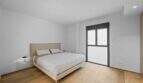 Helles Schlafzimmer der Luxuswohnung am Paseo Marítimo mit Parkettboden, Doppelbett und Balkonzugang.